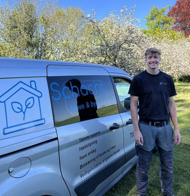 Rasmus Schacht ved firmabilen med Schacht Have & Byg-logoet